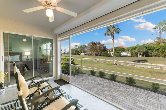 unfurnished sunroom featuring ceiling fan