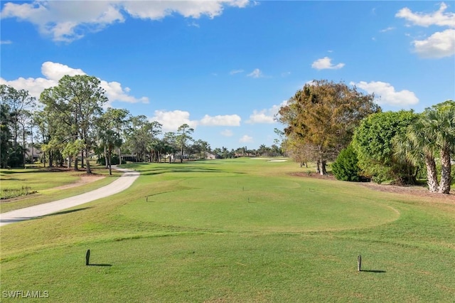 view of home's community featuring view of golf course and a yard