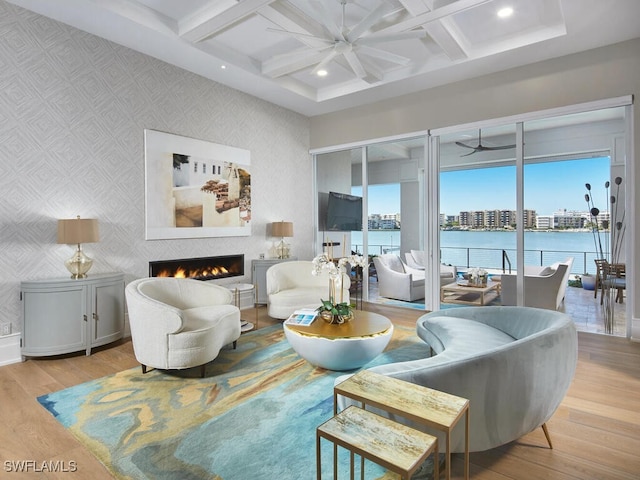 living room featuring beamed ceiling, ceiling fan, coffered ceiling, and light hardwood / wood-style floors