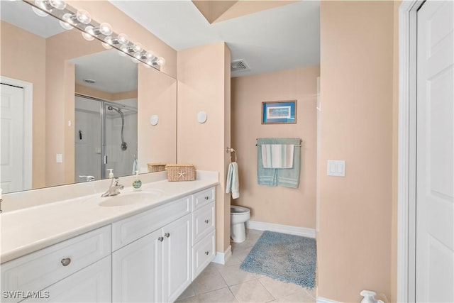 bathroom featuring toilet, vanity, tile patterned floors, and a shower with door