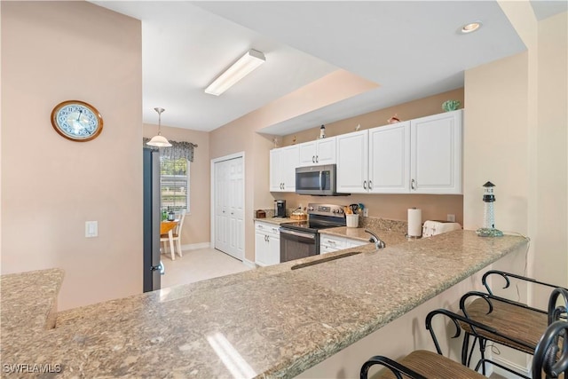 kitchen featuring white cabinetry, kitchen peninsula, decorative light fixtures, a breakfast bar, and appliances with stainless steel finishes