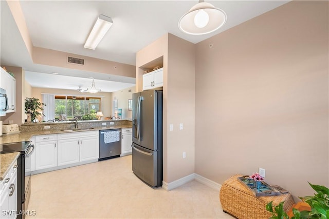 kitchen with light stone countertops, sink, stainless steel appliances, kitchen peninsula, and white cabinets