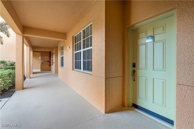 view of exterior entry featuring covered porch