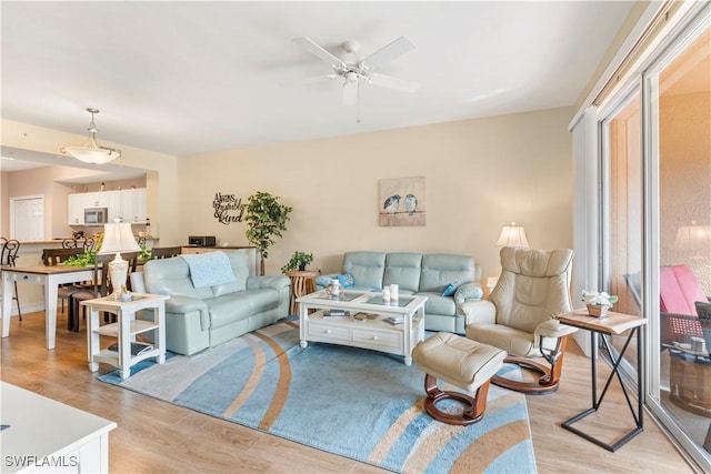 living room featuring ceiling fan and light hardwood / wood-style floors