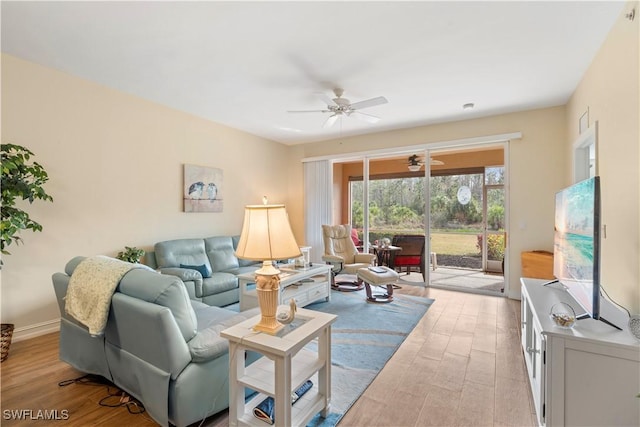 living room featuring ceiling fan and light hardwood / wood-style floors