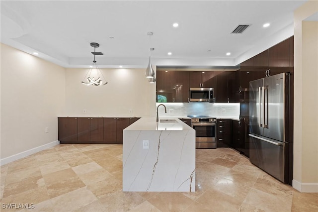 kitchen featuring dark brown cabinetry, sink, hanging light fixtures, and appliances with stainless steel finishes