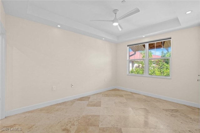 unfurnished room with a raised ceiling and ceiling fan