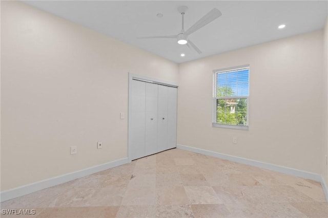 unfurnished bedroom featuring ceiling fan and a closet