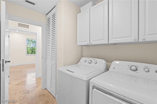 laundry area featuring cabinets, washing machine and dryer, and light tile patterned floors