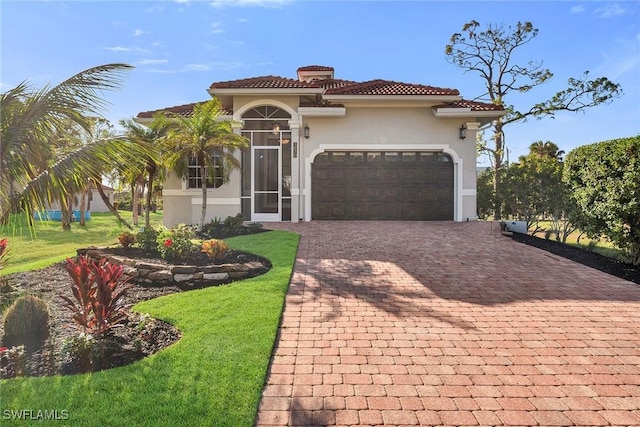 mediterranean / spanish house with a front yard and a garage