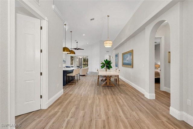 interior space with light hardwood / wood-style floors, vaulted ceiling, and a notable chandelier