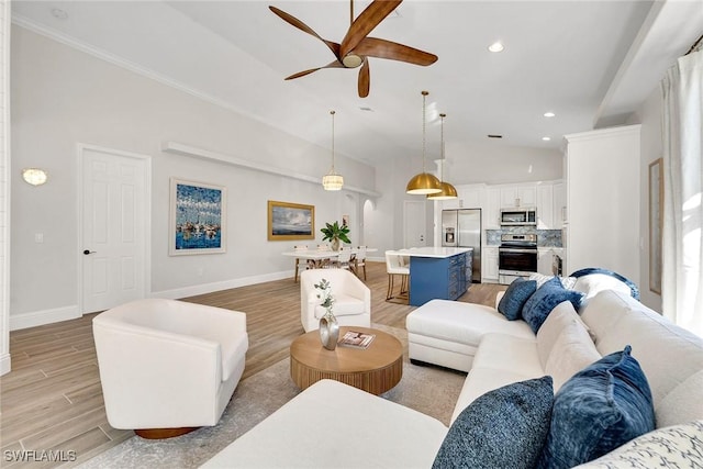 living room with light hardwood / wood-style floors, vaulted ceiling, ceiling fan, and crown molding