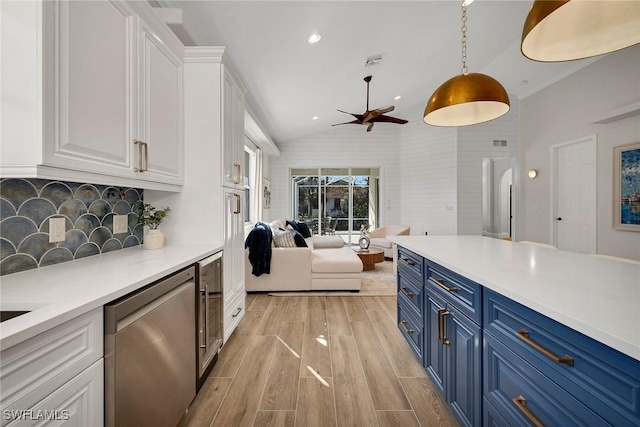 kitchen with blue cabinets, dishwasher, white cabinetry, hanging light fixtures, and lofted ceiling