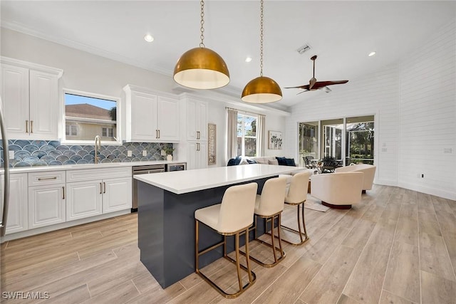 kitchen featuring white cabinets, ceiling fan, and hanging light fixtures