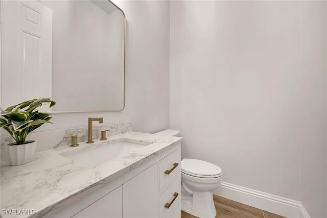 bathroom with vanity, hardwood / wood-style flooring, and toilet