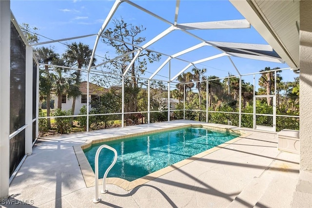 view of swimming pool with glass enclosure and a patio area