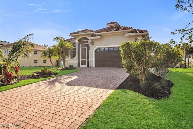 mediterranean / spanish home featuring a garage and a front lawn