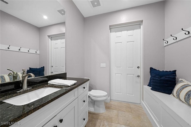 bathroom with tile patterned flooring, vanity, and toilet