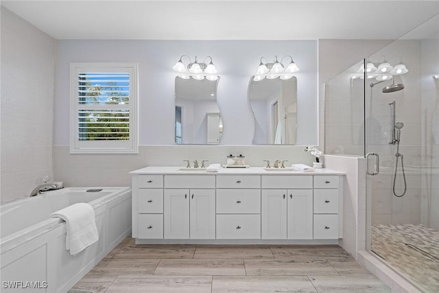 bathroom with vanity and shower with separate bathtub