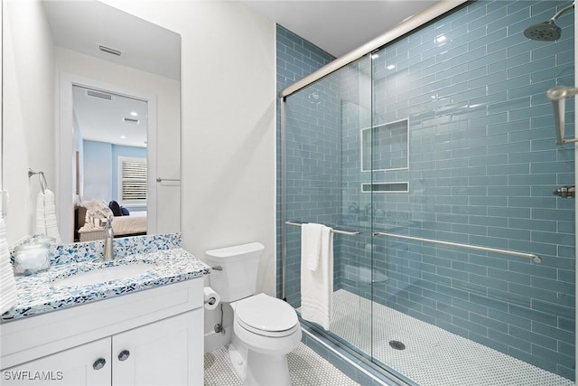 bathroom featuring tile patterned floors, toilet, vanity, and walk in shower