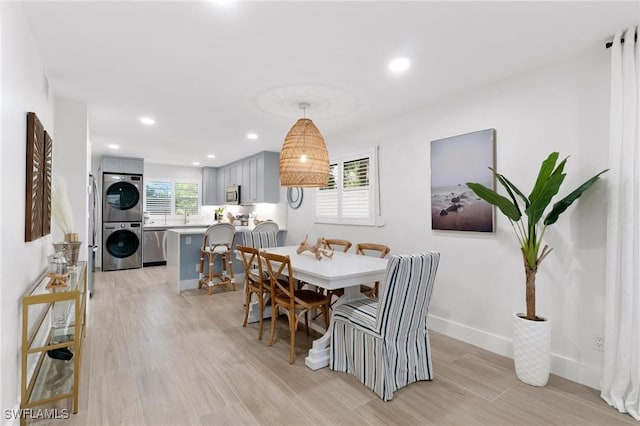 dining area with stacked washer and dryer, visible vents, baseboards, light wood-type flooring, and recessed lighting