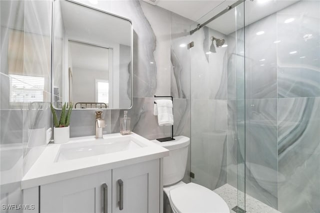 bathroom featuring vanity, toilet, and a shower with door