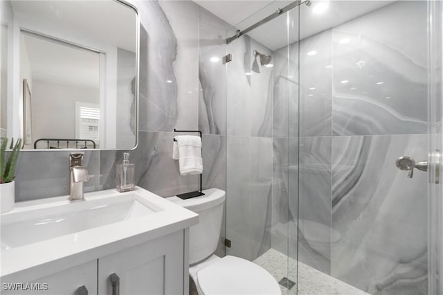 bathroom featuring vanity, toilet, and a shower with shower door