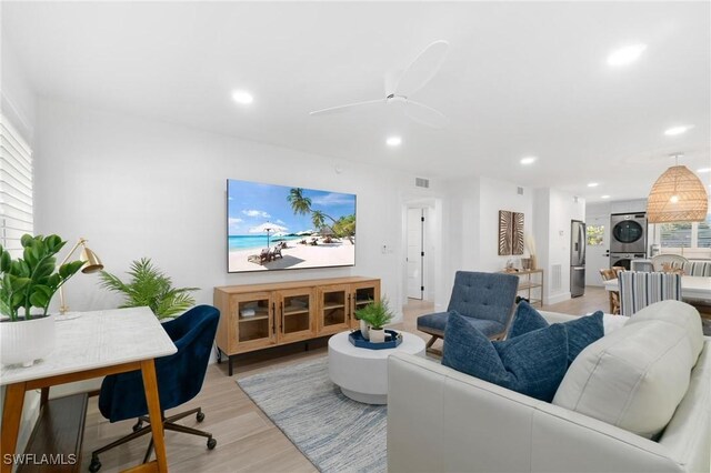 living room featuring light wood-type flooring, recessed lighting, stacked washer and clothes dryer, and visible vents