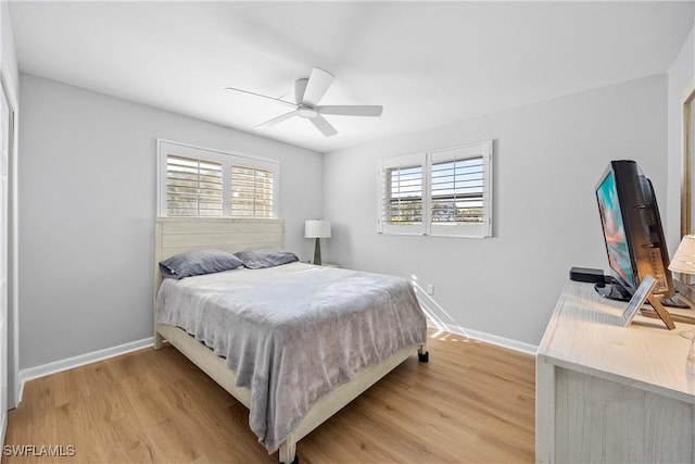 bedroom featuring multiple windows, ceiling fan, and light wood-type flooring