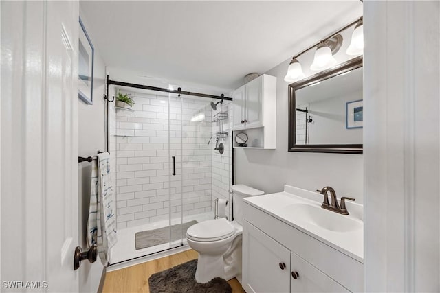 bathroom featuring hardwood / wood-style floors, vanity, toilet, and a shower with door