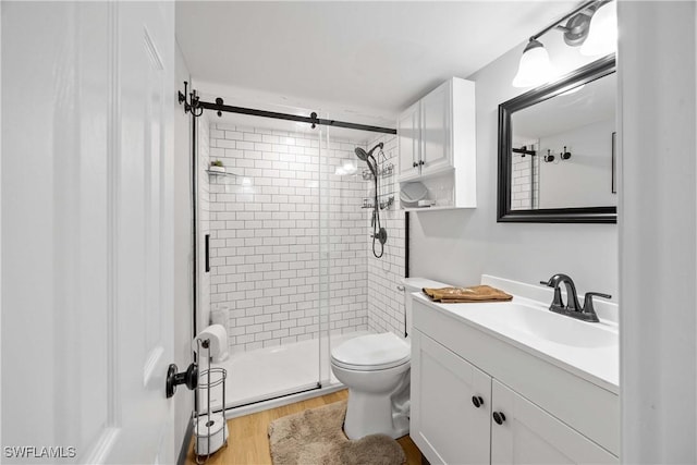 bathroom featuring toilet, vanity, wood-type flooring, and walk in shower