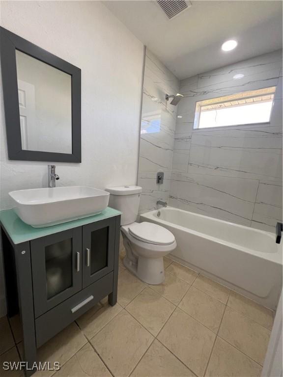 full bathroom with toilet, vanity, tile patterned floors, and tiled shower / bath