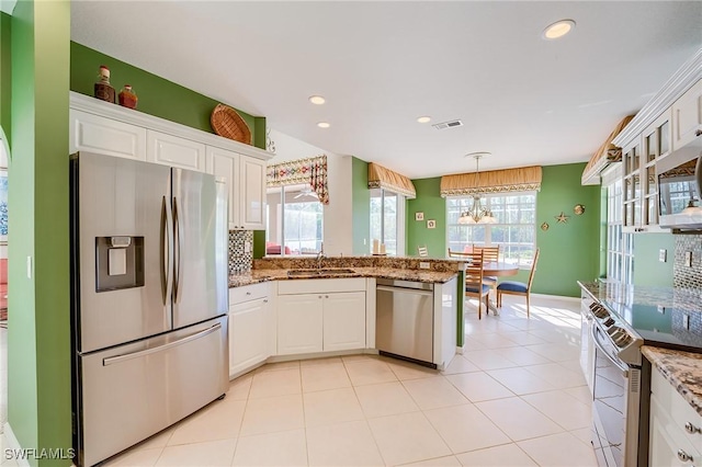 kitchen with backsplash, sink, white cabinetry, and stainless steel appliances