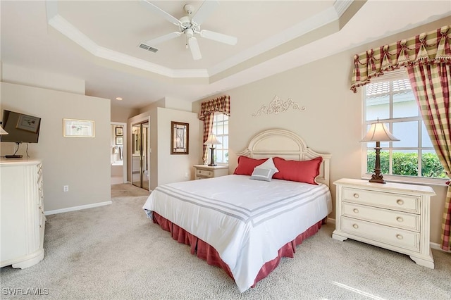 bedroom featuring a tray ceiling, ceiling fan, light colored carpet, and ornamental molding