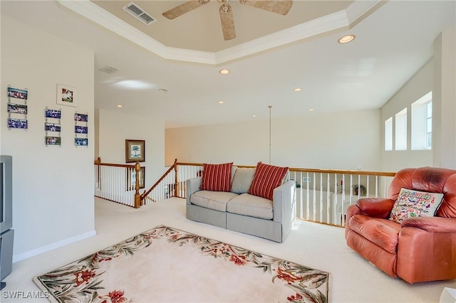 living room featuring a tray ceiling, ceiling fan, and carpet floors