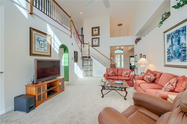 living room featuring carpet, a high ceiling, and an inviting chandelier