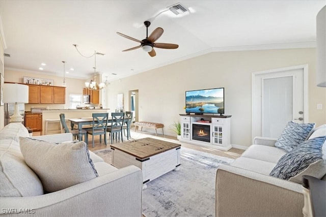 20680 Vita Ct, Venice, FL 34293 - living area featuring a chandelier, a ceiling fan, crown molding, a glass covered fireplace, and lofted ceiling