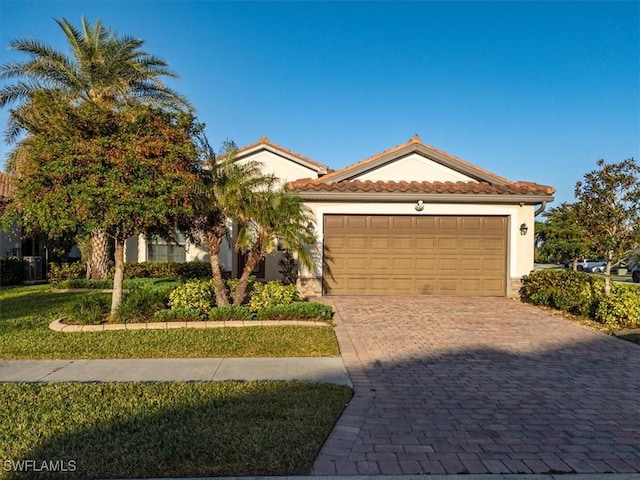20680 Vita Ct, Venice, FL 34293 - mediterranean / spanish-style home featuring a garage, driveway, stucco siding, and a tiled roof