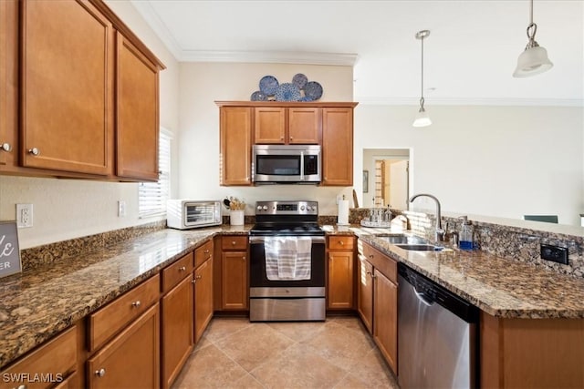 20680 Vita Ct, Venice, FL 34293 - kitchen with stainless steel appliances, a peninsula, ornamental molding, brown cabinetry, and pendant lighting