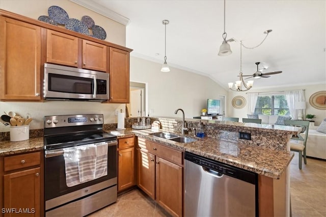 20680 Vita Ct, Venice, FL 34293 - kitchen with appliances with stainless steel finishes, a peninsula, brown cabinets, open floor plan, and ornamental molding