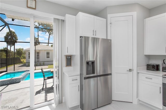 kitchen with white cabinetry and stainless steel fridge with ice dispenser