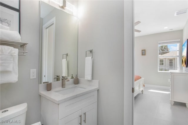 bathroom with tile patterned flooring, vanity, toilet, and ceiling fan