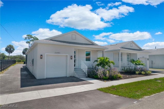 single story home featuring covered porch and a garage