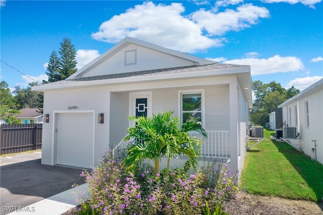 view of front of home featuring a porch, central AC, and a garage