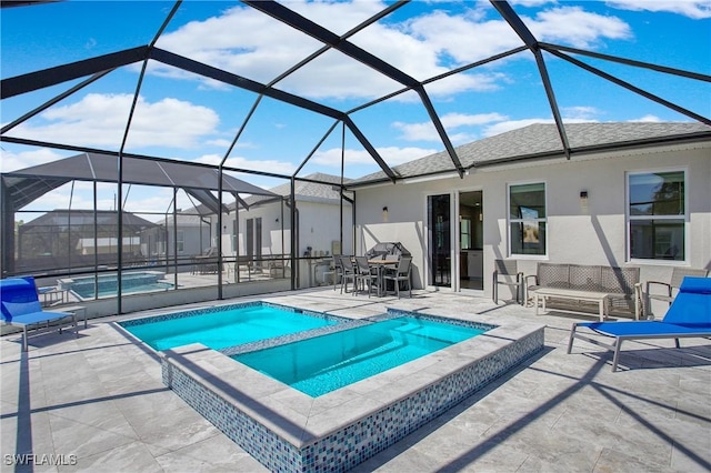 view of pool with a lanai, a patio area, and an in ground hot tub