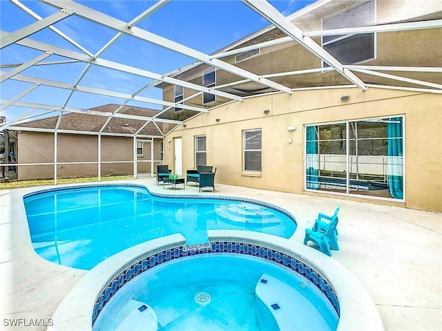 view of swimming pool with glass enclosure, an in ground hot tub, and a patio area