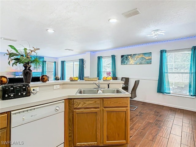 kitchen with dishwasher, wood-type flooring, a textured ceiling, and sink