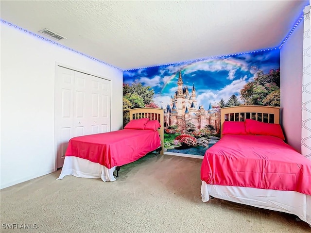 carpeted bedroom with a textured ceiling and a closet