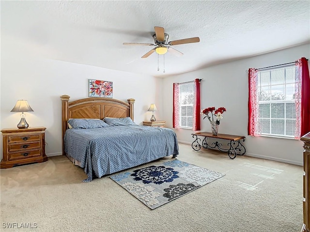 carpeted bedroom featuring ceiling fan, a textured ceiling, and multiple windows