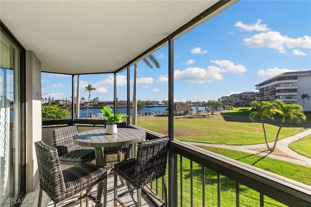 sunroom featuring a water view